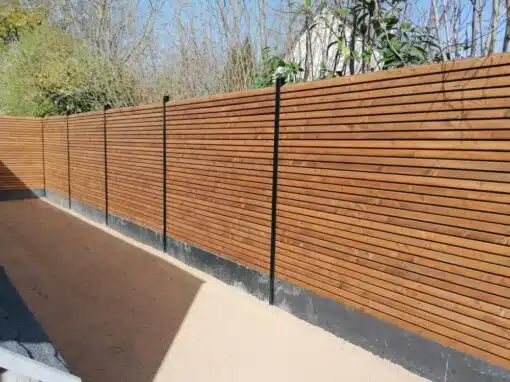 clôture vibrato traité marron poteaux alu noir soubassement dalle d'ardoise